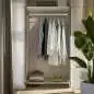 Preview: Edelstahl-Garderobenstange aus Vierkantrohr mit Wandflansch, montiert in einem stilvollen Kleiderschrank mit aufgehängter Kleidung