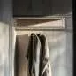 Preview: Maßgefertigte Edelstahl-L-förmige Garderobenstange montiert in einem stilvollen Kleiderschrank mit Kleidung, die an der Stange hängt